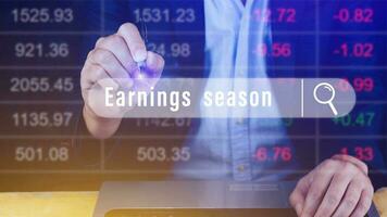 Earnings season Hand touching of written in search bar with the financial data visible in the background,  Reports Stock Market Ticker Words photo