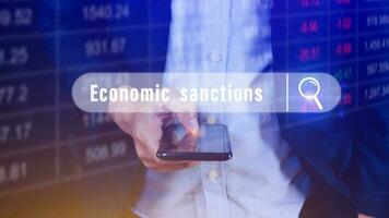Economic sanctions, written in search bar with the financial data visible on background with smartphone. Reports Stock Market Ticker Words photo