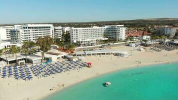 ayia napa, Chipre - 15 abril, 2023 - lujo hotel edificios con quinielas por playa con isla verdor panorama. vehículos en nisi bahía estacionamiento. video