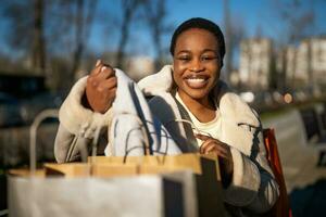 Beautiful afro woman with shopping bags outdoors photo