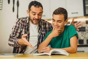 padre es Ayudar su hijo con aprendiendo. ellos son haciendo deberes juntos. foto