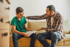 Father is helping his son with learning. They are doing homework together. photo