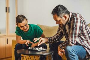 Father and son are playing chess at home. photo