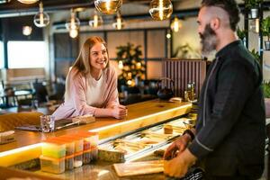 joven mujer con Sushi cocinero foto