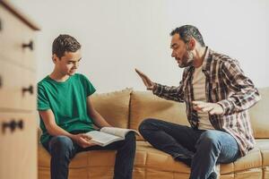 Father is helping his son with learning. They are doing homework together. photo