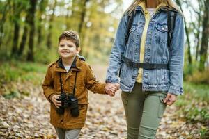 Mother and son hiking in the forest photo