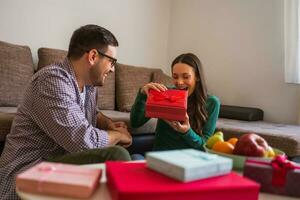 Pareja es compartiendo regalos en su hogar foto