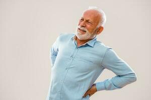 Portrait of an elderly man having back pains photo