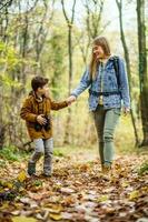 Mother and son hiking in the forest photo