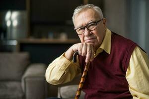 Elderly man with cane at home photo