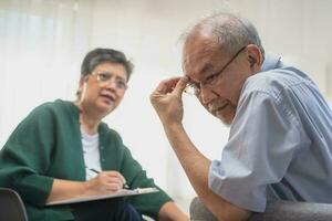 Psychology, depression people. Elderly asian adult man, men consulting with psychologist ,psychiatrist while elderly, old patient counseling mental with doctor woman at clinic. Encouraging, therapy. photo