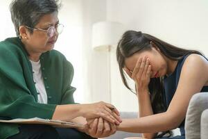 Psychology, depression. sad asian young woman cry about break up or divorce, consulting with psychologist ,psychiatrist while patient counseling mental with doctor at clinic. Encouraging, therapy. photo