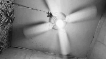 negro y blanco vídeo ventilador gira debajo techo en México. video