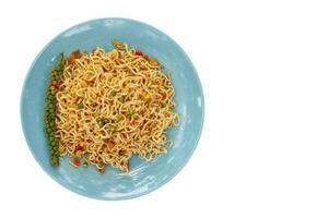 Top view of Spicy stir fried instant noodle in blue plate isolated on white background included clipping path. photo