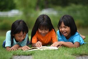 grupo de niños acostado leyendo en césped campo foto