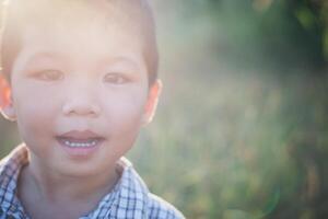 Portrait of happy little boy laughing while he play in the park. photo