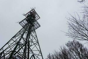 transmission tower at a mountain with gray sky photo