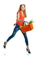 Young caucasian woman with assorted grocery products in shopping basket isolated on white photo