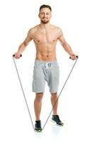 Athletic attractive man jumping on a rope on the white photo