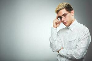 joven hombre con lentes pensando foto