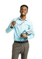 contento africano americano Universidad estudiante con libros y botella de agua en su manos en pie en blanco foto