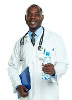 Portrait of a smiling male doctor holding bottle of water on white photo