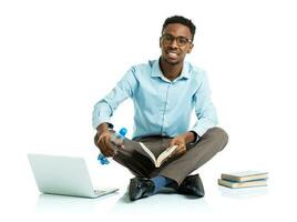 Happy african american college student with laptop, books and bottle of water sitting on white photo