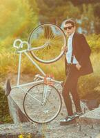 joven elegante chico con bicicleta al aire libre foto