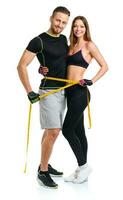 Happy athletic couple - man and woman with measuring tape on the white photo