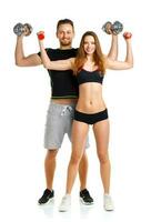 Sport couple - man and woman with dumbbells on the white photo