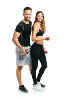 Athletic couple - man and woman with dumbbells on the white photo