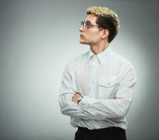 Young serious man in glasses in profile photo