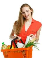 Happy woman holding a basket full of healthy food. Shopping photo