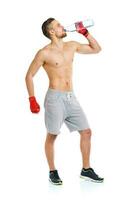 deporte atractivo hombre vistiendo boxeo vendajes y Bebiendo Fresco agua en el blanco foto