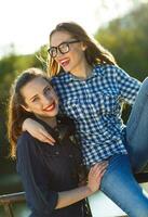 Two playful young girl having fun outdoors at sunset light photo