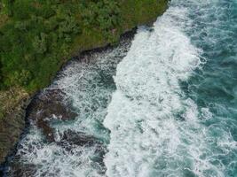 aéreo ver de el olas golpear el costero arrecifes foto