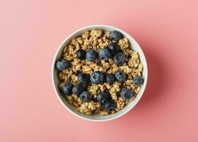 Granola con arándano en cuenco en rosado antecedentes. foto