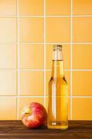 Apple cider in a bottle on a wooden table photo