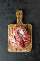 Raw beef meat on a wooden cutting board photo