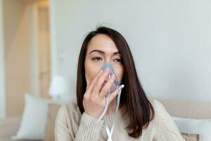 enfermo asiático mujer haciendo inhalación, medicina es el mejor medicamento. enfermo mujer vistiendo un oxígeno máscara y pasando tratamiento para COVID-19. mujer con un inhalador foto