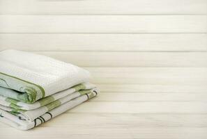 A pile of neatly folded towels on wooden background. Production of natural textile fibers.Organic product. Natural cloth photo