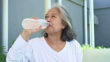 contento asiático mayor mujer son Bebiendo agua desde botella para bueno salud. bueno salud, estilo de vida. video