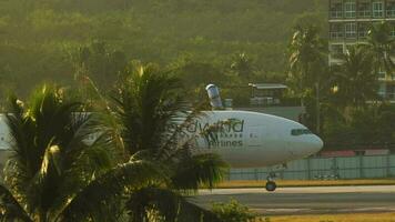 phuket, thailand november 13, 2019 - boeing 777 nordvind flygbolag taxibilar efter landning på phuket flygplats terminal på solnedgång. passagerare transport. resa och flyg video