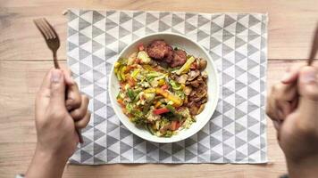 jeune homme avec une fourchette en attente d'une assiette pleine de légumes video