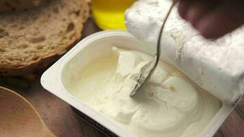 Close up of low fact cheese cream in a container on table video