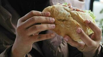 hand holding beef burger on table close up . video