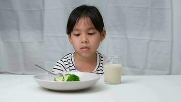 niños no lo hagas me gusta a comer vegetales. linda asiático niña negarse a comer sano vegetales. nutrición y sano comiendo hábitos para niños. video