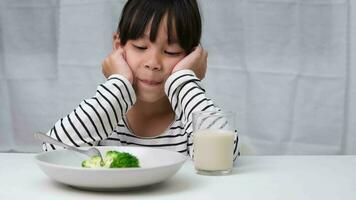 niños no lo hagas me gusta a comer vegetales. linda asiático niña negarse a comer sano vegetales. nutrición y sano comiendo hábitos para niños. video