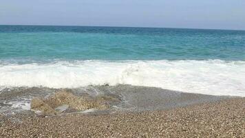 White waves of the sea hitting the rock and shore on the beach video