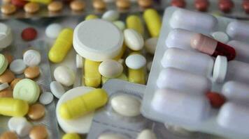 Immagine di confezionato e Aperto pillole posto su un' rotante sfondo, colorato droghe, medico medicinale, Salute settore video